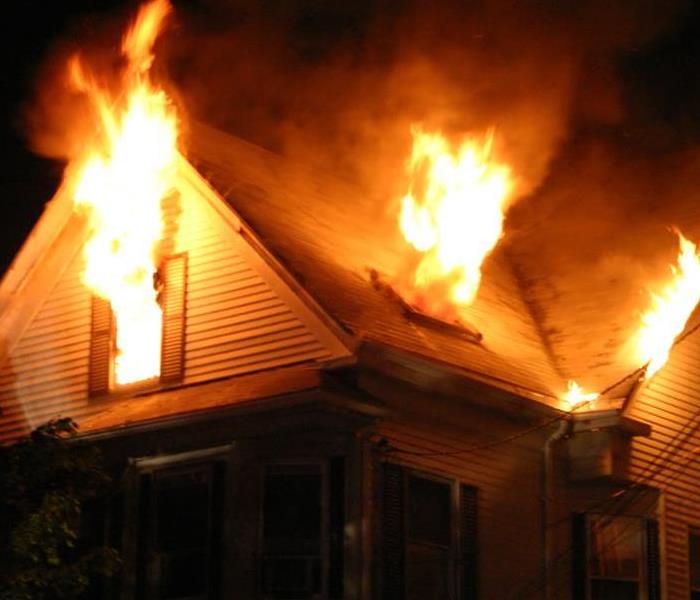 A home on fire in the dark of night. 