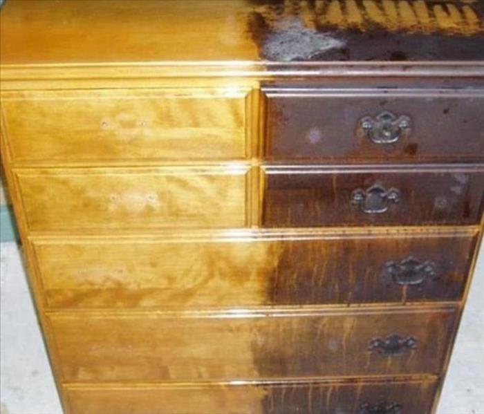 fire damaged dresser before and after; half restored and half showing charring and soot damage