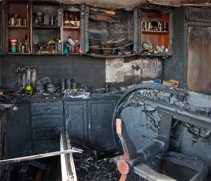 a fire damaged kitchen with soot covering the walls and cabinets