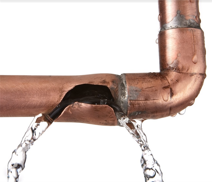 a broken copper pipe with water leaking from it